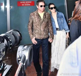 ​巩俐抵达戛纳第一天放大招！和老公走机场排面真大，穿白裙太美了