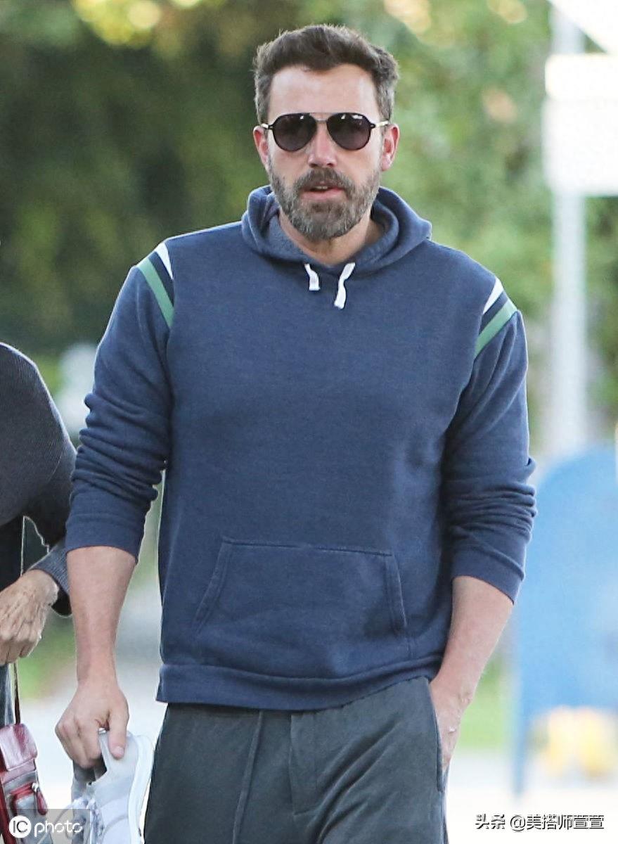 本·阿弗莱克穿蓝色卫衣难掩肌肉线条，搭灰色运动裤休闲舒适