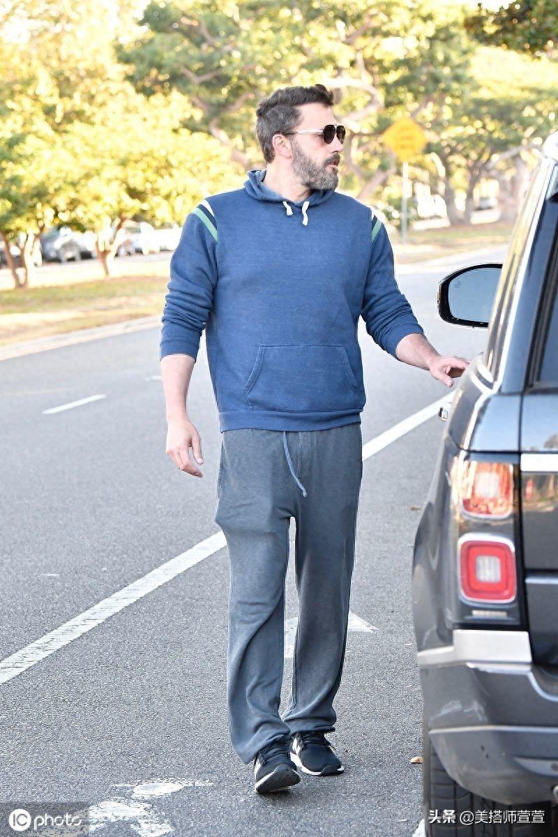 本·阿弗莱克穿蓝色卫衣难掩肌肉线条，搭灰色运动裤休闲舒适